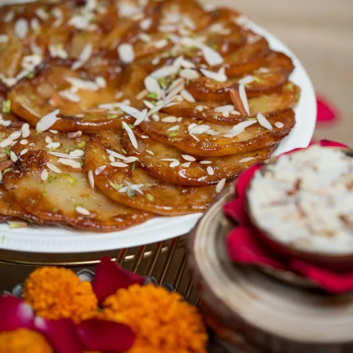 Malpua — Fennel-scented fried pancakes dipped in syrup.