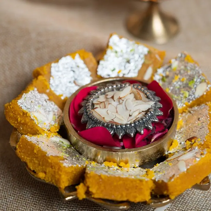Kesar Malai Barfi — Soft milk barfi with saffron and pistachio.