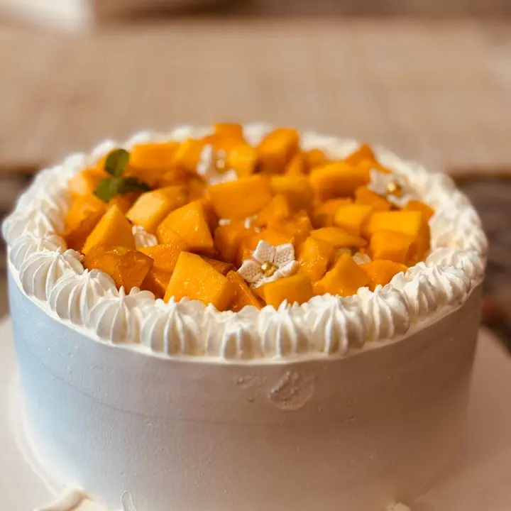 Mango Cream Cake — Mango cream layers with fresh mango on top.